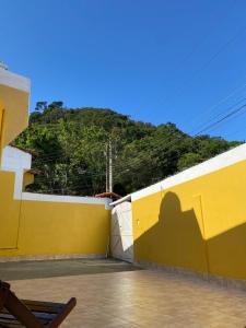 a shadow of a man on a yellow wall at Casa na praia 6 camas e 4 colchoes in Mongaguá