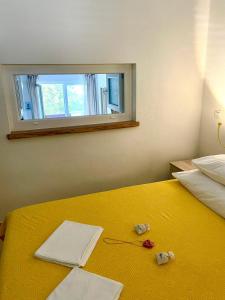 a bedroom with a yellow bed with a window at Ribarica GO green 2 in Ribarica