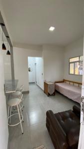 a room with a bed and a couch and a table at Casa na praia 6 camas e 4 colchoes in Mongaguá