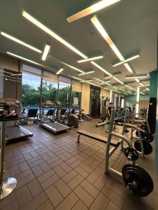 a gym with several treadmills and machines in a room at Executive Suites Bellagio Golf View Residences in Manila