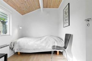 a bedroom with a bed and a chair in it at 6787-Allinge-Fjeldvej-8 in Allinge