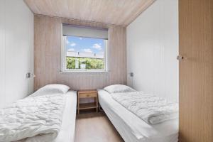 two beds in a small room with a window at 6683-Allinge-Brunekulvej-2-D in Allinge
