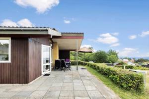a patio with chairs and an umbrella next to a house at 6683-Allinge-Brunekulvej-2-D in Allinge