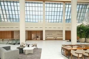 a lobby with tables and chairs and large windows at Courtyard by Marriott Pyeongtaek in Pyeongtaek +47 photos