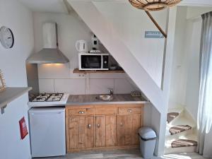 a kitchen with a sink and a microwave at Appartement vlakbij strand en centrum in Zoutelande
