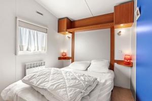 Un dormitorio con una cama blanca y una ventana. en Marinière, en Sainte-Croix-du-Verdon