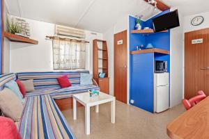 Una sala de estar con un sofá azul y una mesa. en Marinière, en Sainte-Croix-du-Verdon