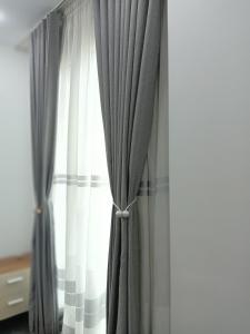 une fenêtre avec des rideaux gris et blancs dans une pièce dans l'établissement Logement idéal pour vos séjours - 8ème étage avec ascenseur, à Birmandreis