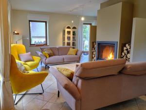 a living room with couches and a fire place at Chimay Nature Hideaway in Chimay