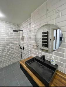 une salle de bain avec un lavabo noir et un miroir dans l'établissement Logement idéal pour vos séjours - 8ème étage avec ascenseur, à Birmandreis