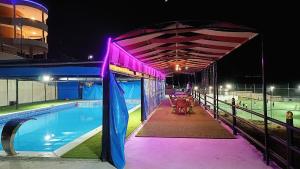 a swimming pool at night with a lit up canopy at Neverland Resort مزرعة نيفرلاند in Irbid