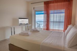a bedroom with a bed with a view of the ocean at Kiveri Apartments in Kiveri