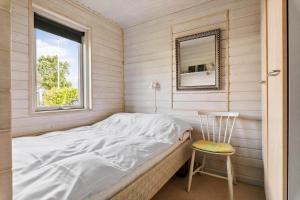 a bed in a room with a mirror and a chair at OH526-Hadsund-Ved-Fruerlund-32 in Hadsund