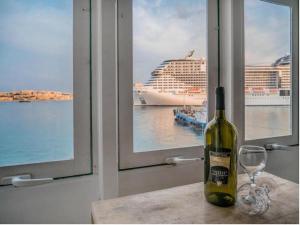 a bottle of wine sitting on a table next to a window at SeaFront Apartment In Valletta in Valletta +12 photos