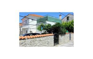 a house with a stone wall and a fence at Amazing Apartment In Supetar in Supetar