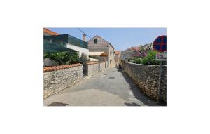 a street with a stone wall and a street sign at Amazing Apartment In Supetar in Supetar