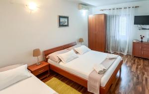 a bedroom with two beds and a flat screen tv at Amazing Apartment In Supetar in Supetar