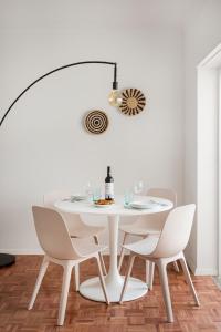 a white dining room with a white table and chairs at Estoril Beach - Your Family Escape in Estoril +34 photos