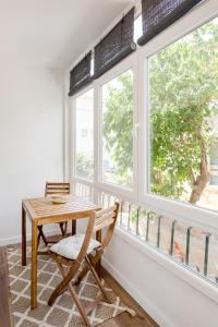 a table and a chair in a room with windows at Estoril Beach - Your Family Escape in Estoril