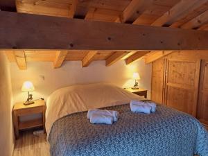 a bedroom with a bed with two towels on it at Chalet spacieux avec vue magnifique in Saint-Marcel