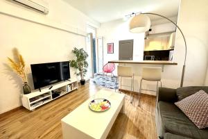 a living room with a couch and a table at Spacious cocoon close to the beach in Ajaccio
