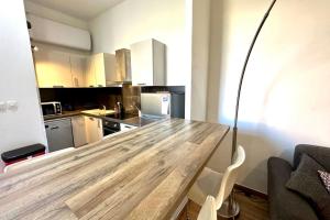 a kitchen with a wooden table in a room at Spacious cocoon close to the beach in Ajaccio