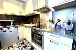 a kitchen with white cabinets and a stove top oven at Spacious cocoon close to the beach in Ajaccio