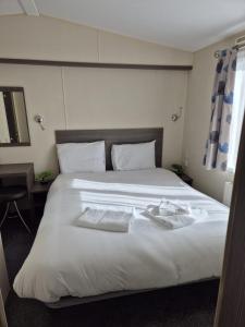 a bedroom with a large white bed with towels on it at Valley side - 3 bedrooms sleeps 8 in Burmarsh