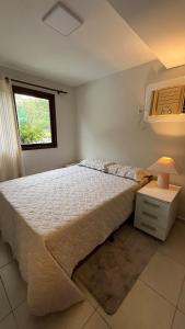 een slaapkamer met een groot bed en een raam bij Chalé no Privê Monte Serrat com 3 quartos em Gravatá in Gravatá