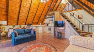 ein Wohnzimmer mit einer blauen Couch und einer Küche in der Unterkunft Villa Ilgın Panoramic Mountain & Sea Views, Secluded Retreat in Aklar