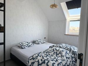 a bedroom with a bed with two pillows on it at Duinzicht in Westende-Bad