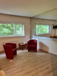 a living room with two chairs and a mirror at Le Phoenica - Former Hotel - Parking in Carquefou