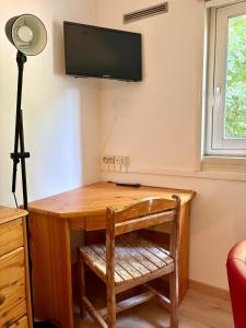 a desk with a television on a wall at Le Phoenica - Former Hotel - Parking in Carquefou
