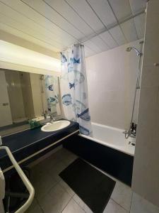 a bathroom with a sink and a tub and a shower at Le Phoenica - Former Hotel - Parking in Carquefou