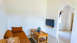 a living room with a couch and a table with a laptop at Private Cozy House in Nembrala