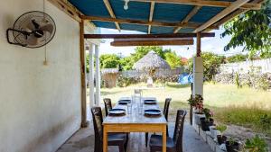 a table with chairs sitting under a pergola at Private Cozy House in Nembrala