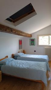 two beds in a bedroom with a window at Villa Monte Adone in Santa Cecilia
