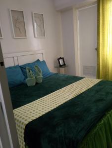 a bedroom with a bed with two shoes on it at Mary's Crib Cityland Prime Tagaytay with Free Wifi & Swimming in Tagaytay +10 photos