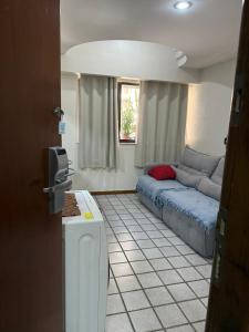 Una sala de estar con un sofá azul y una ventana. en Flat Pasárgada III (apt 116), en Vila Velha 19 fotos más