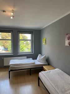 two beds in a room with two windows at 1, 2 und 3 Zimmer Monteurwohnungen in Egeln in Egeln
