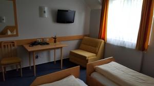 a hotel room with a bed and a chair and a tv at Restaurant Gästehaus Seiger in Sankt Lorenzen bei Knittelfeld +26 photos