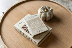 une table avec trois livres et une citrouille dessus dans l'établissement Welcoming House - Walking distance to Town Centre - Sleeps 5 - Free Parking, Self-Check-In, Fast WiFi and Smart TV by Yoko Property, à Rugby