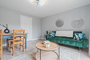 un salon avec un canapé vert et une table dans l'établissement Welcoming House - Walking distance to Town Centre - Sleeps 5 - Free Parking, Self-Check-In, Fast WiFi and Smart TV by Yoko Property, à Rugby