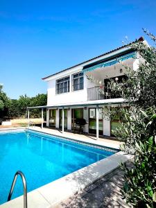 a house with a swimming pool in front of a building at Finca Azafrán - Chalet con piscina privada in Sanlúcar la Mayor