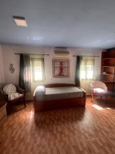 a bedroom with a bed and two chairs at Finca Azafrán - Chalet con piscina privada in Sanlúcar la Mayor +21 photos