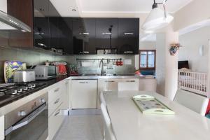 Una cocina con gabinetes blancos y encimera. en La Terrazza Appartamento Agata, en Sirmione