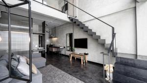 a living room with a staircase in a loft at The Ex Capital Hotel Bangkok by Dancenter in Bangkok