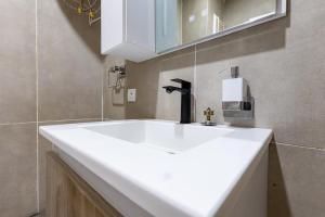a bathroom with a white sink and a mirror at Adouna Appartement d'Exception vue sur mer in Dakar +15 photos