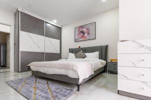 a bedroom with a large bed and a dresser at Adouna Appartement d'Exception vue sur mer in Dakar