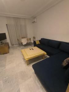 a living room with a blue couch and a table at S1 lux jardin carthage in Tunis